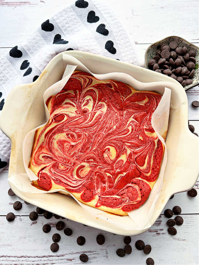 a pan of just baked bright red and cream colored cream cheese swirled brownies
