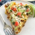 This skillet taco pizza recipe might just become a new favorite in your house! A tasty cornbread crust is topped with ground beef and your favorite taco toppings.