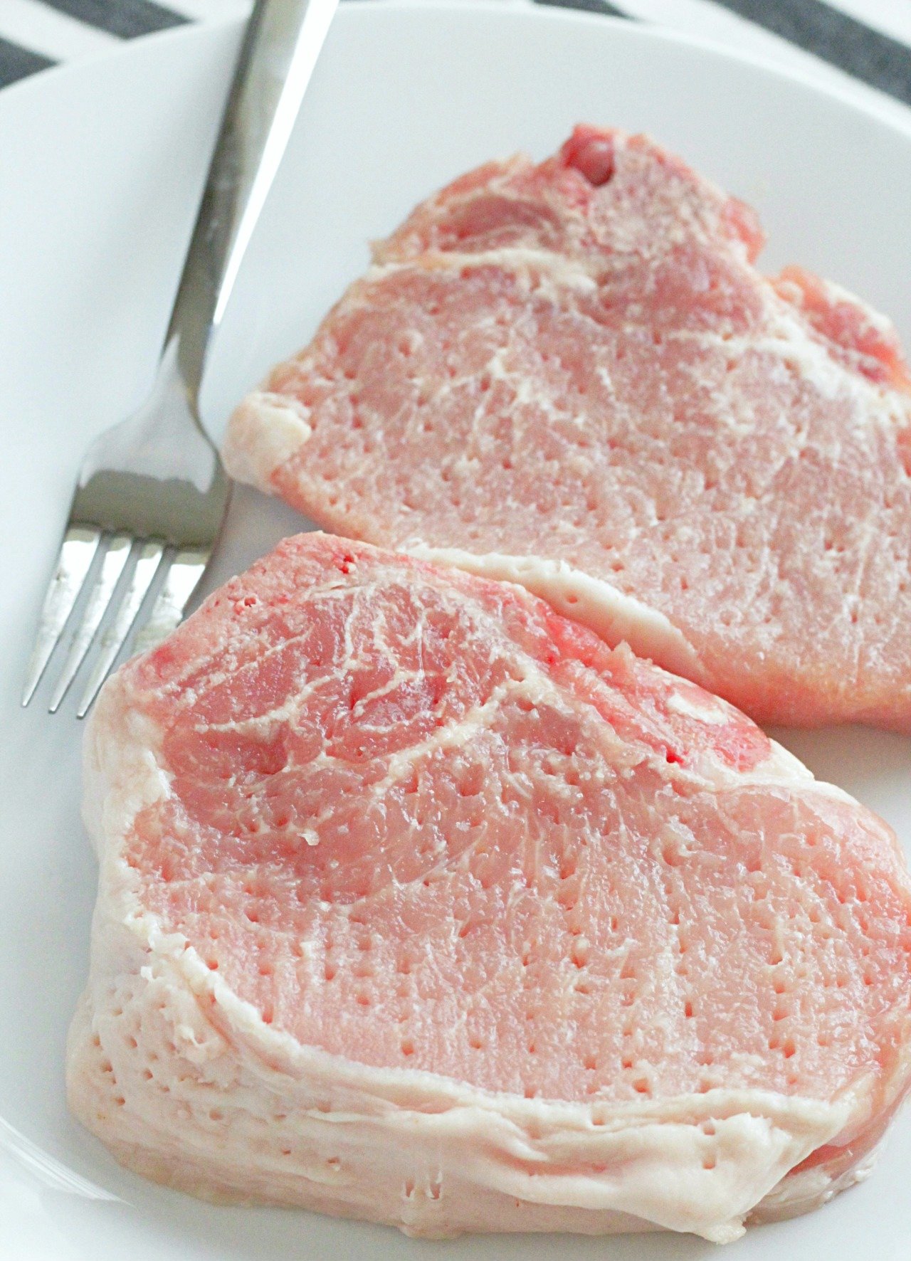 raw pork chops on a plate