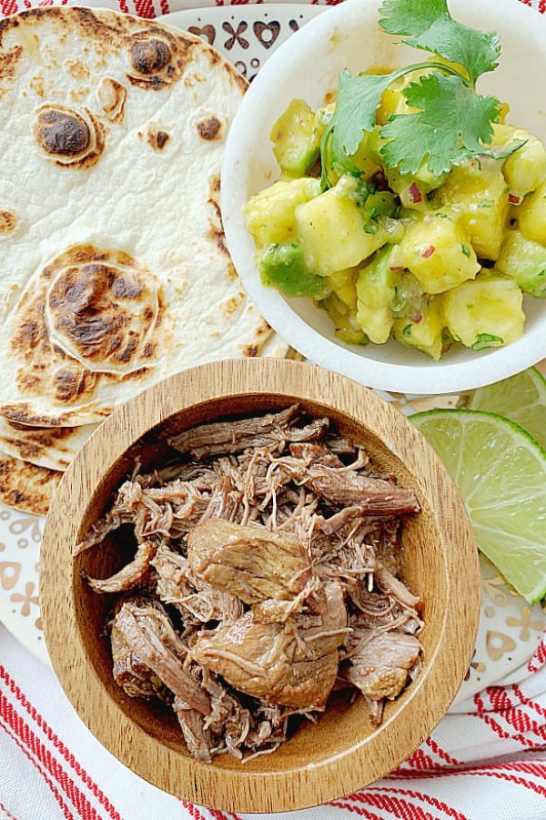 tortillas, pineapple salsa and short rib meat on a plate