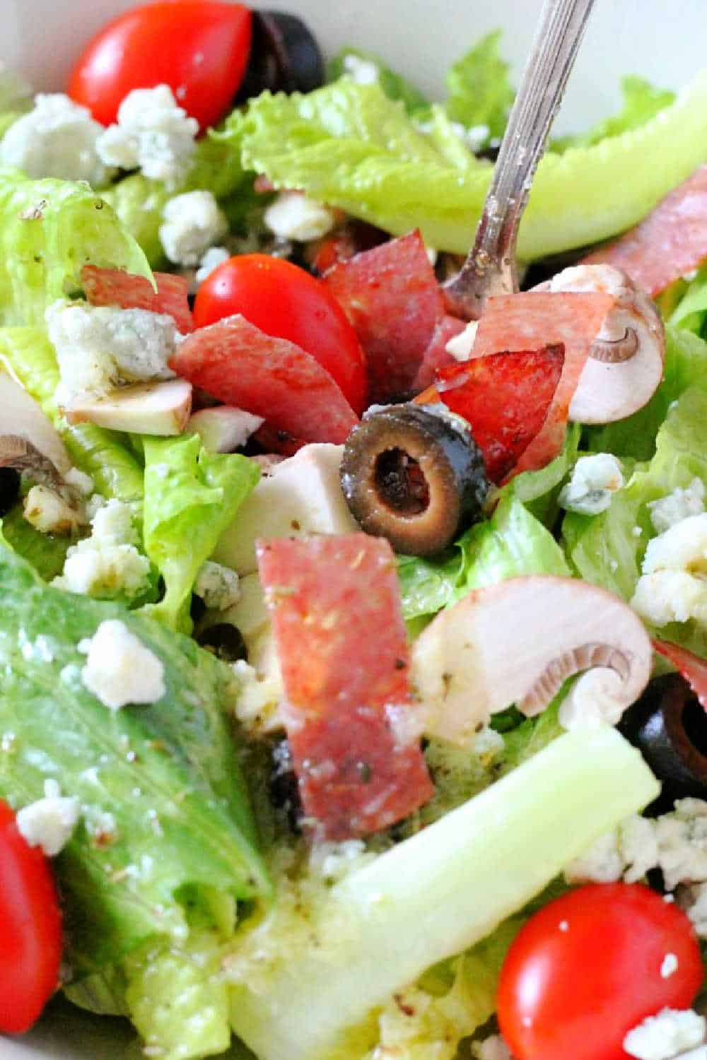 This copycat Lou Malnati's salad will help take you on a virtual trip to Chicago. Sweet Italian dressing tops romaine, tomatoes, mushrooms and black olives - the crispy salami helps to really make this a stand-out salad. via @foodtasticmom