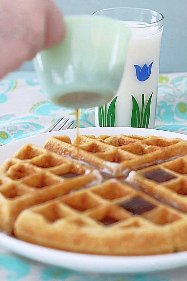 syrup being poured over whole grain belgian waffle