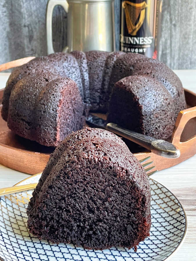 a plated slice of Guinness chocolate bundt with a can of Guinness beer in the background