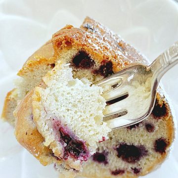 taking a bite out of a slice of blueberry bundt cake