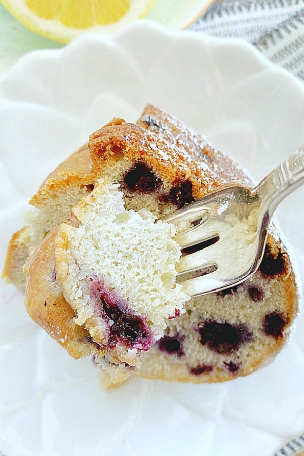 taking a bite out of a slice of blueberry bundt cake