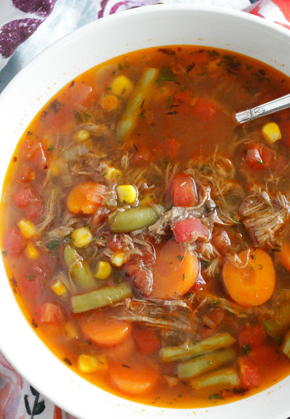 top view of beef vegetable soup in cream colored bowl