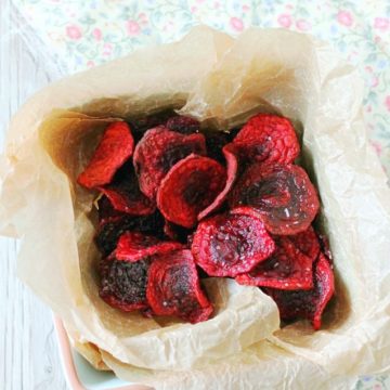 fried beet chips overhead view in basket with parchment paper