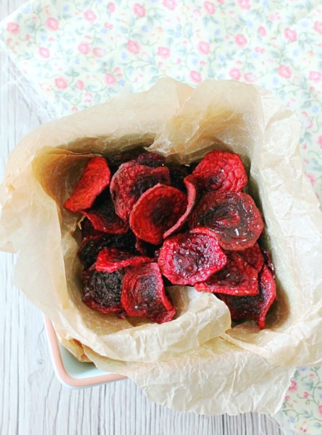 fried beet chips overhead view in basket with parchment paper