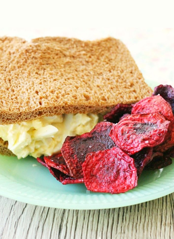 fried beet chips on plate with egg salad sandwich