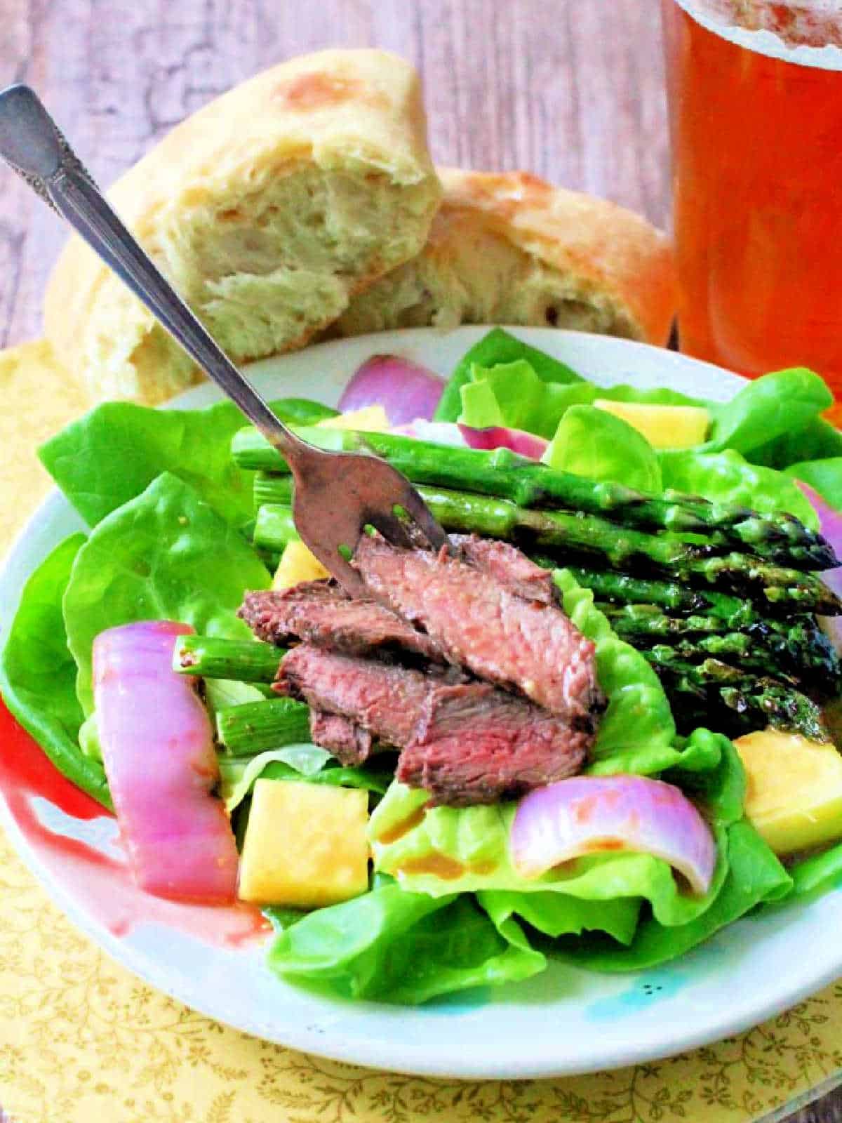 plated steak salad topped with pineapple vinaigrette