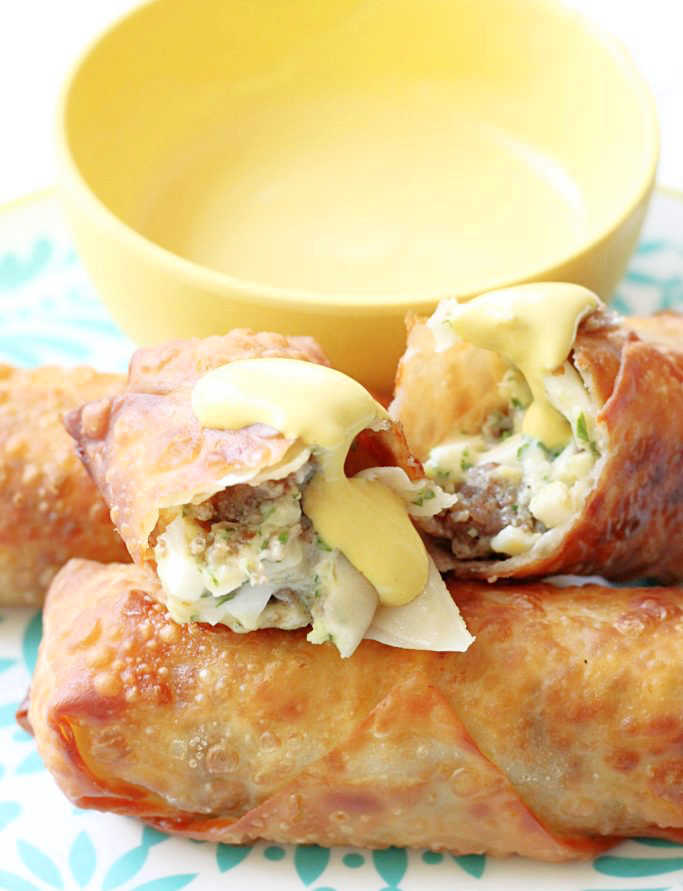 scotch egg rolls plated and cut in half to show egg and sausage filling