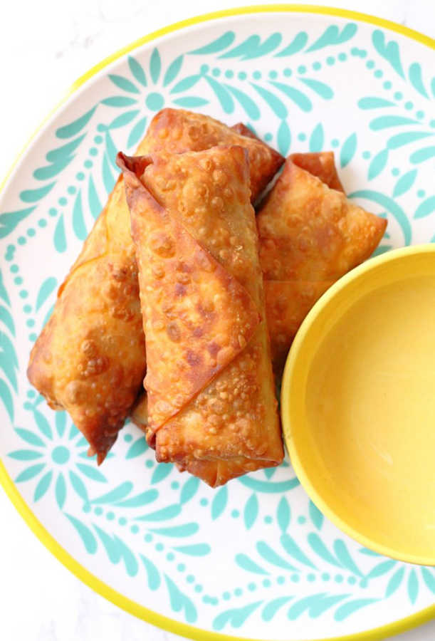 scotch egg rolls plated with a small bowl of mustard dipping sauce