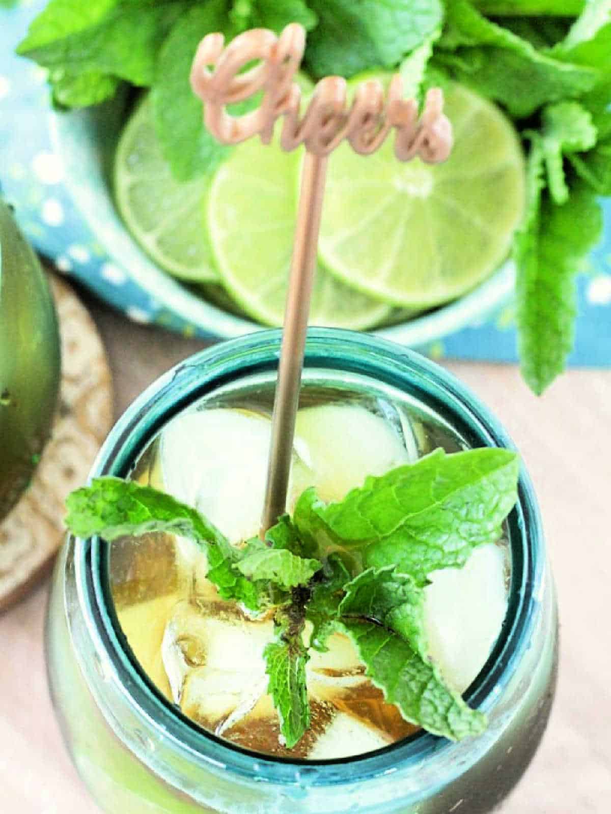 a glass of mojito iced tea with a cheers twizzler in it