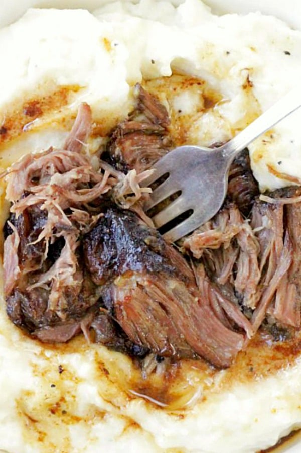 slow cooker short ribs overhead shot on bed of mashed potatoes with gravy