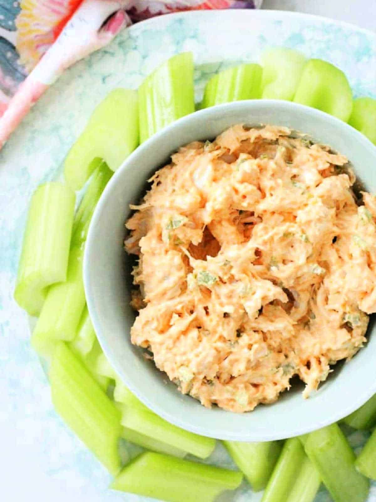 bowl of healthy buffalo chicken dip surrounded by celery