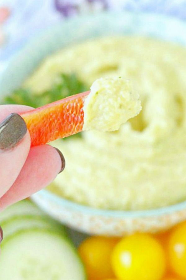 dipping red pepper in tahini free hummus