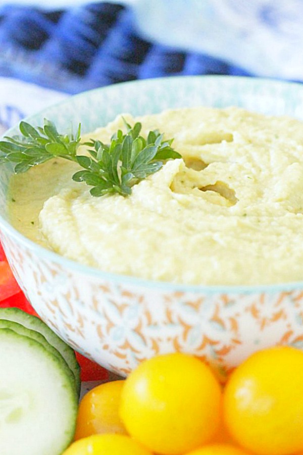 side view of tahini free hummus in bowl topped with fresh parsley