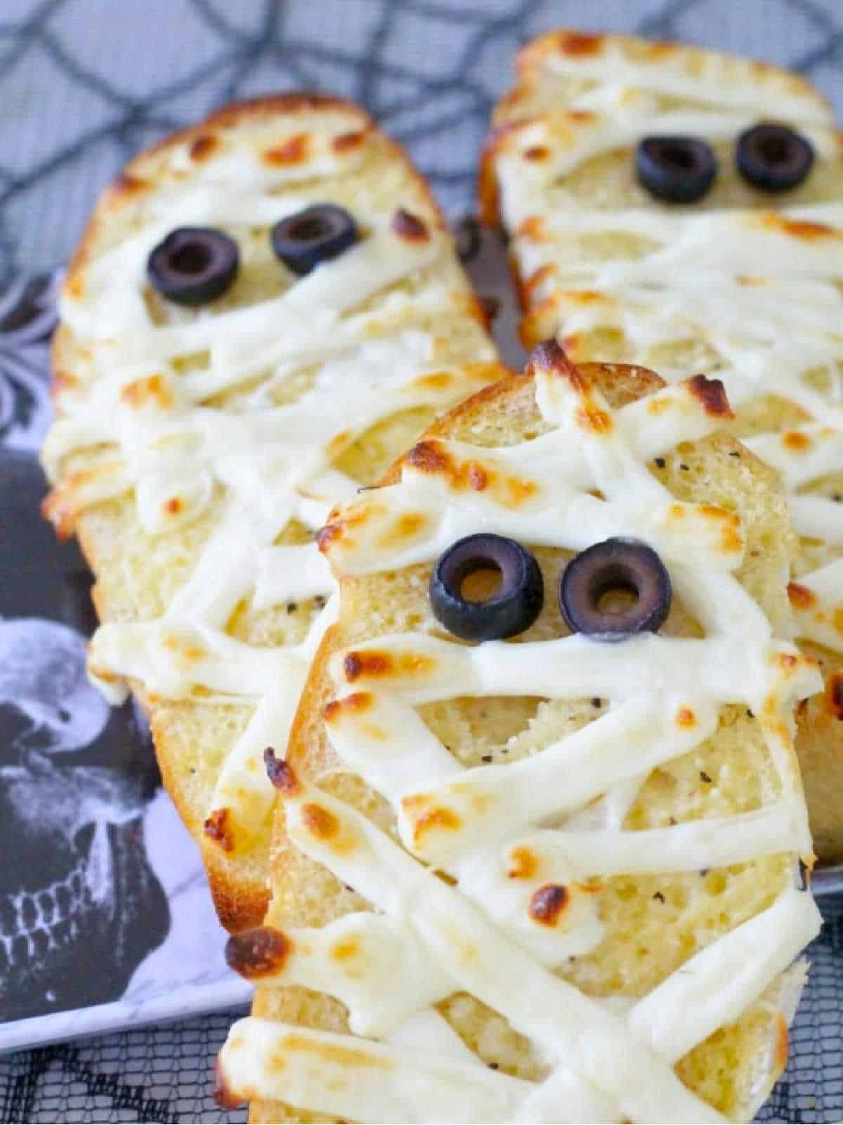 close up photo of three garlic bread mummies