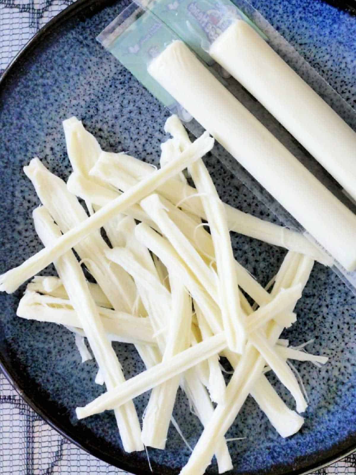 showing string cheese torn into strips on a plate