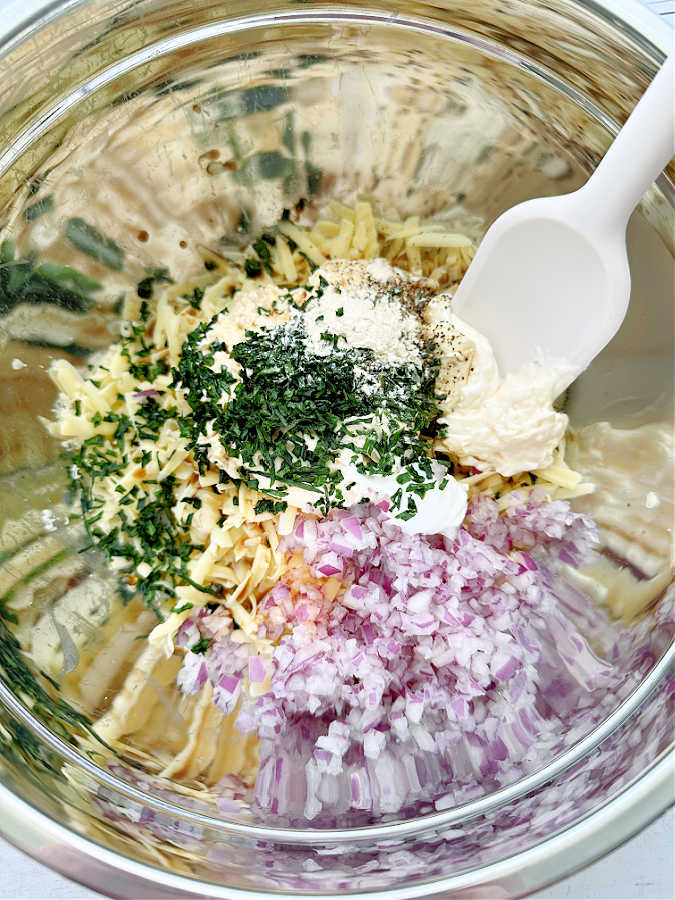 mixing together all the ingredients together in a silver mixing bowl