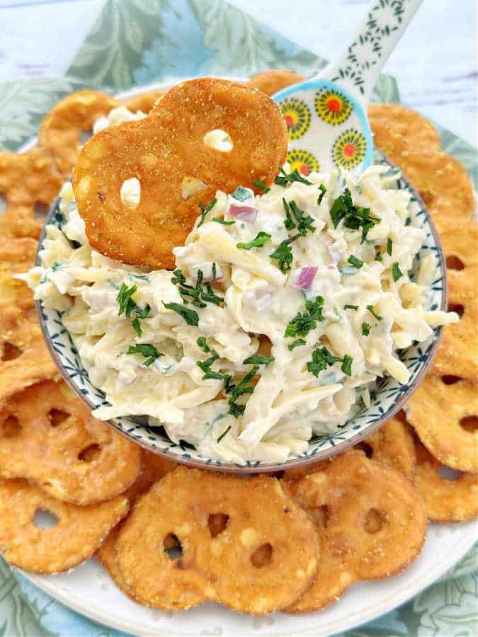 jarlsberg cheese dip in a bowl with decorative spoon and pretzel dippers