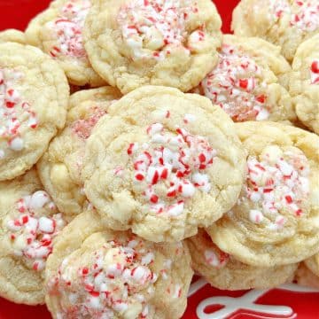 two dozen white chocolate peppermint cookies plated on a red and white merry christmas plate