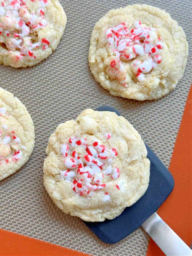 using a spatula to remove a cookie from the baking sheet