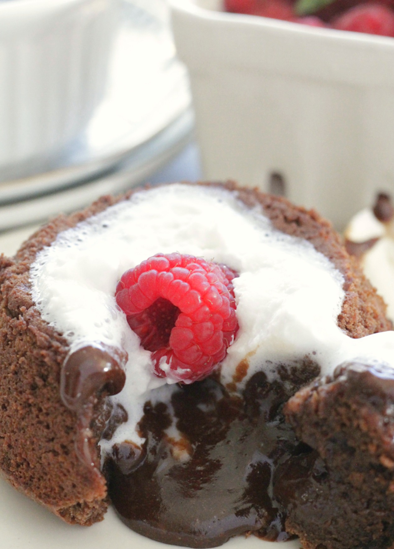 lava cake inverted on plate with whipped cream and raspberry