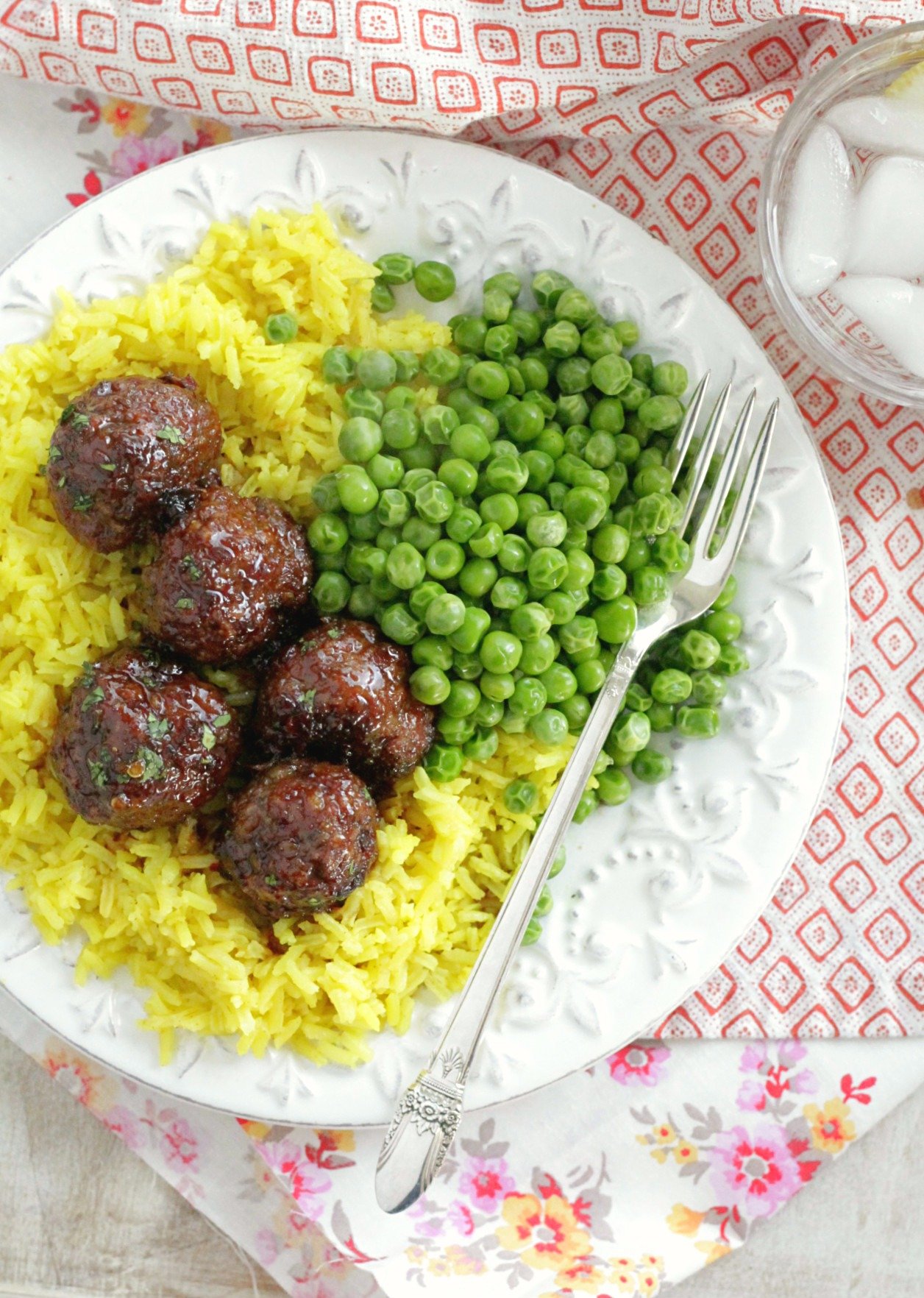 lemon rice on a plate with meatballs and peas