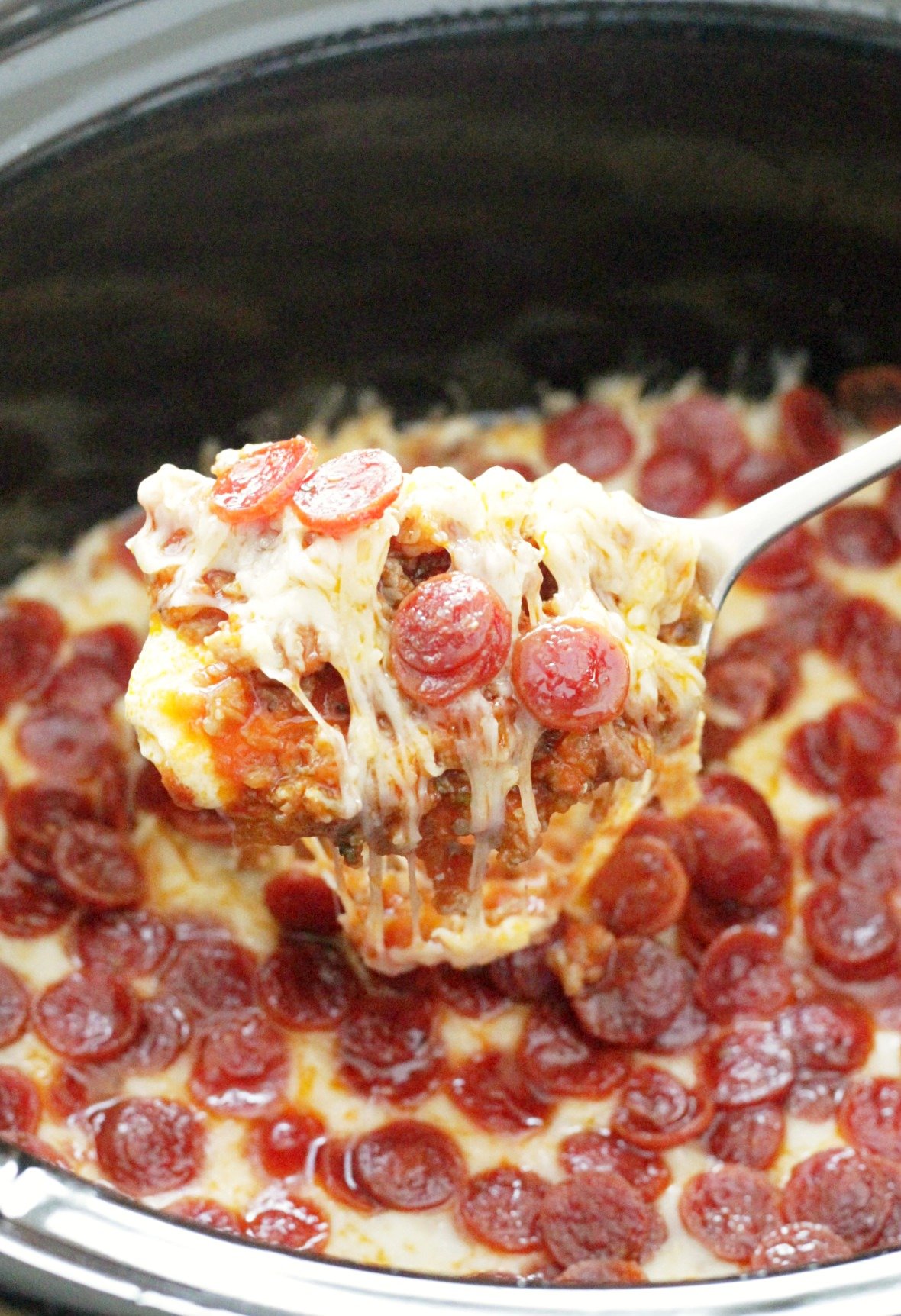 pizza dip in slow cooker with spoon