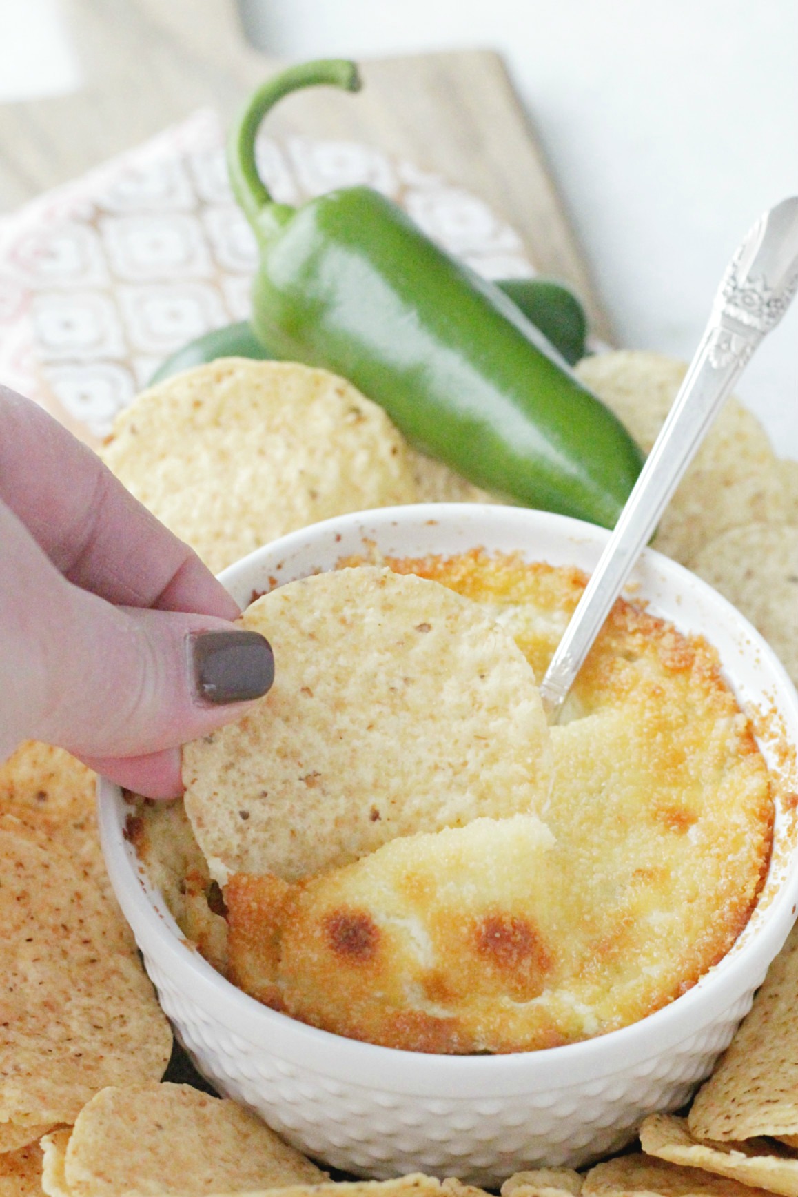 tortilla chip being dipped into popper dip