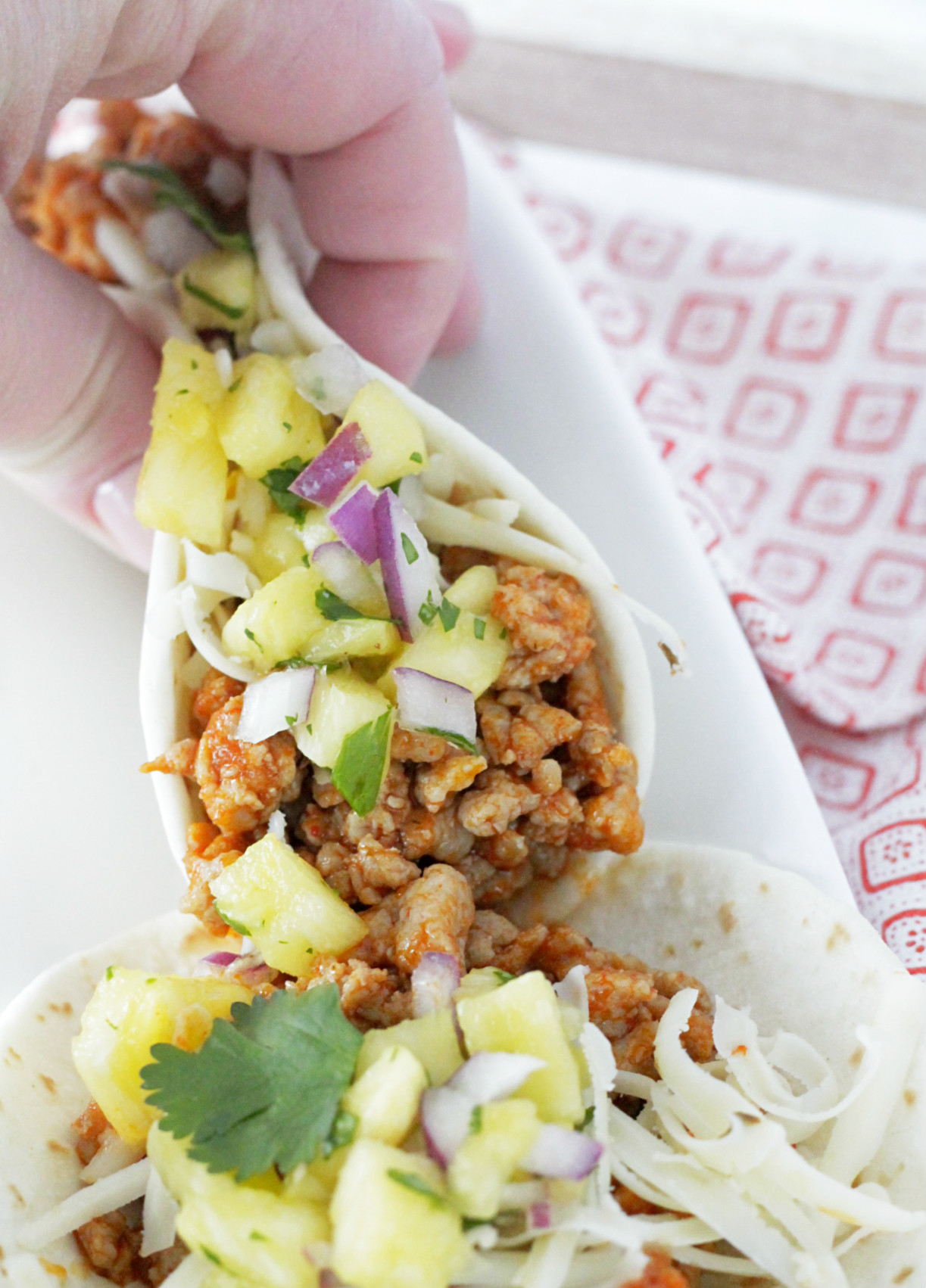 ground pork tacos being held in hand