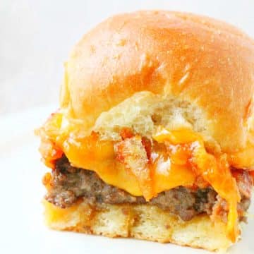 Serve these meatloaf sliders at your next party and everyone will be asking you for the recipe. Made with a unique way of baking the meatloaf seasoned burger and topped with french fried onions, cheddar and a sweet and tangy sauce.