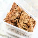 cooked shredded beef in individual meal prep containers