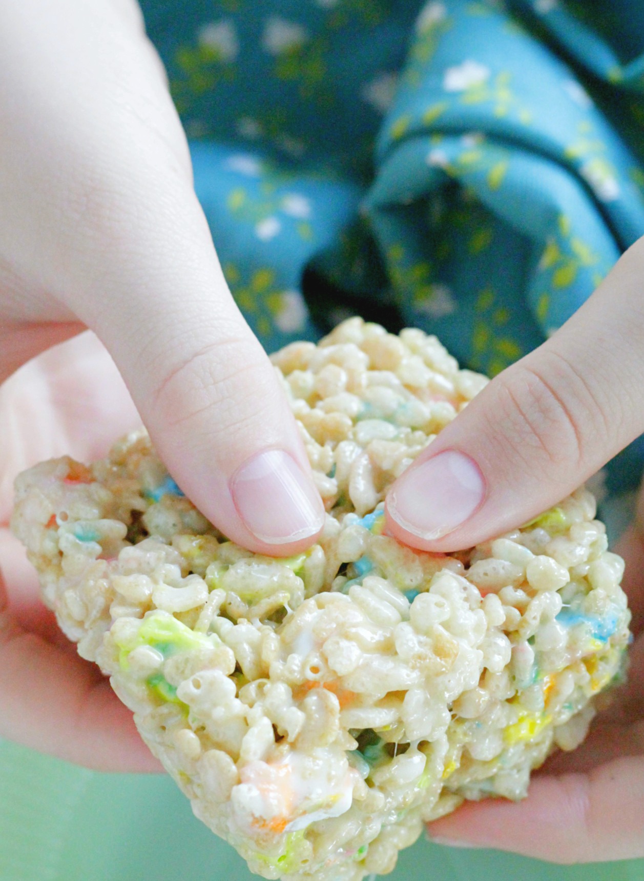 st. patrick's day krispie treat square being held in boy's hands