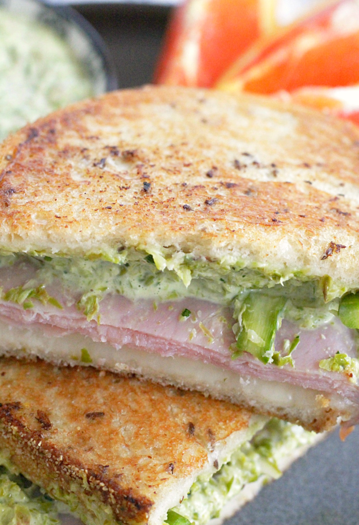 close up of grilled ham and cheese sandwich with asparagus sliced in half