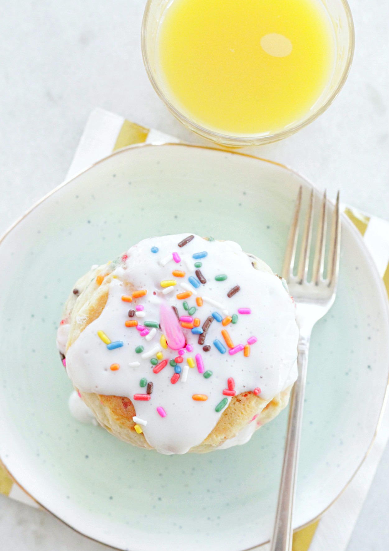 birthday cake pancakes on plate with glass of orange juice