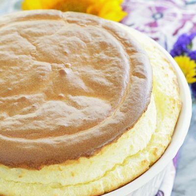side view of classic cheese soufflé with flower in the background