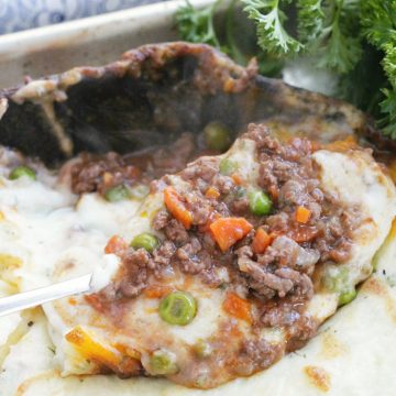 showing the beef and gravy filling underneath the mashed potato topping of the skillet shepherd's pie