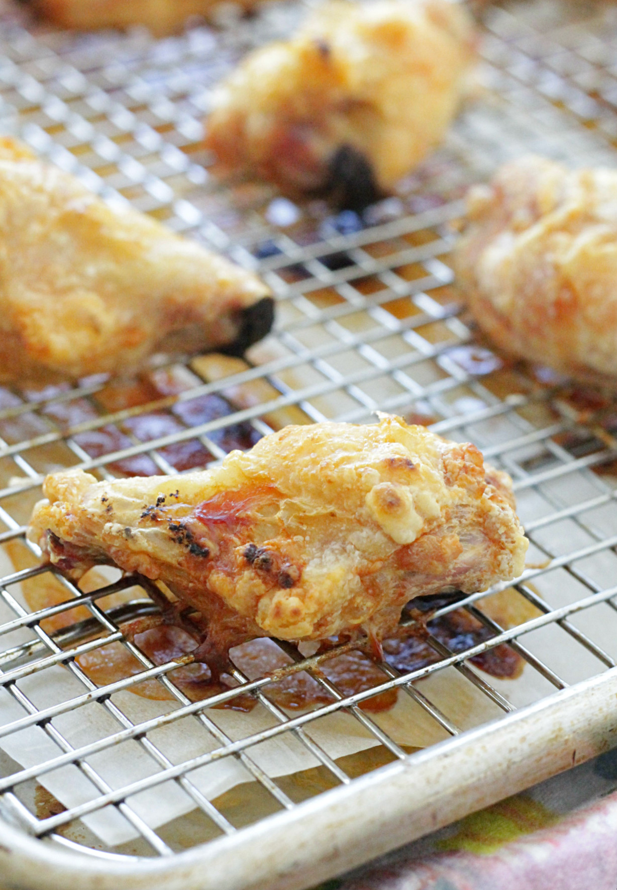 crispy baked chicken wings on sheet pan lined with baking rack showing how crisp the wings are after just being baked