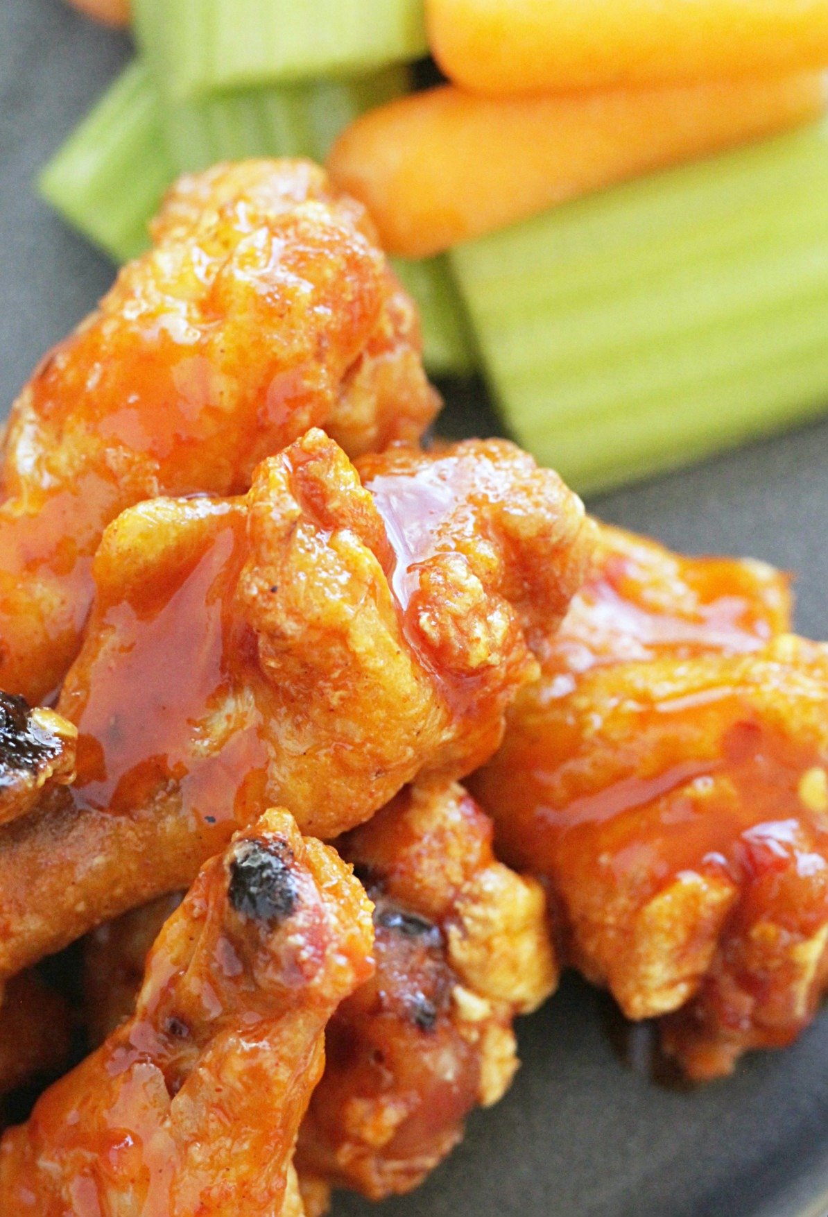 close up of crispy baked chicken wings showing off the buffalo sauce