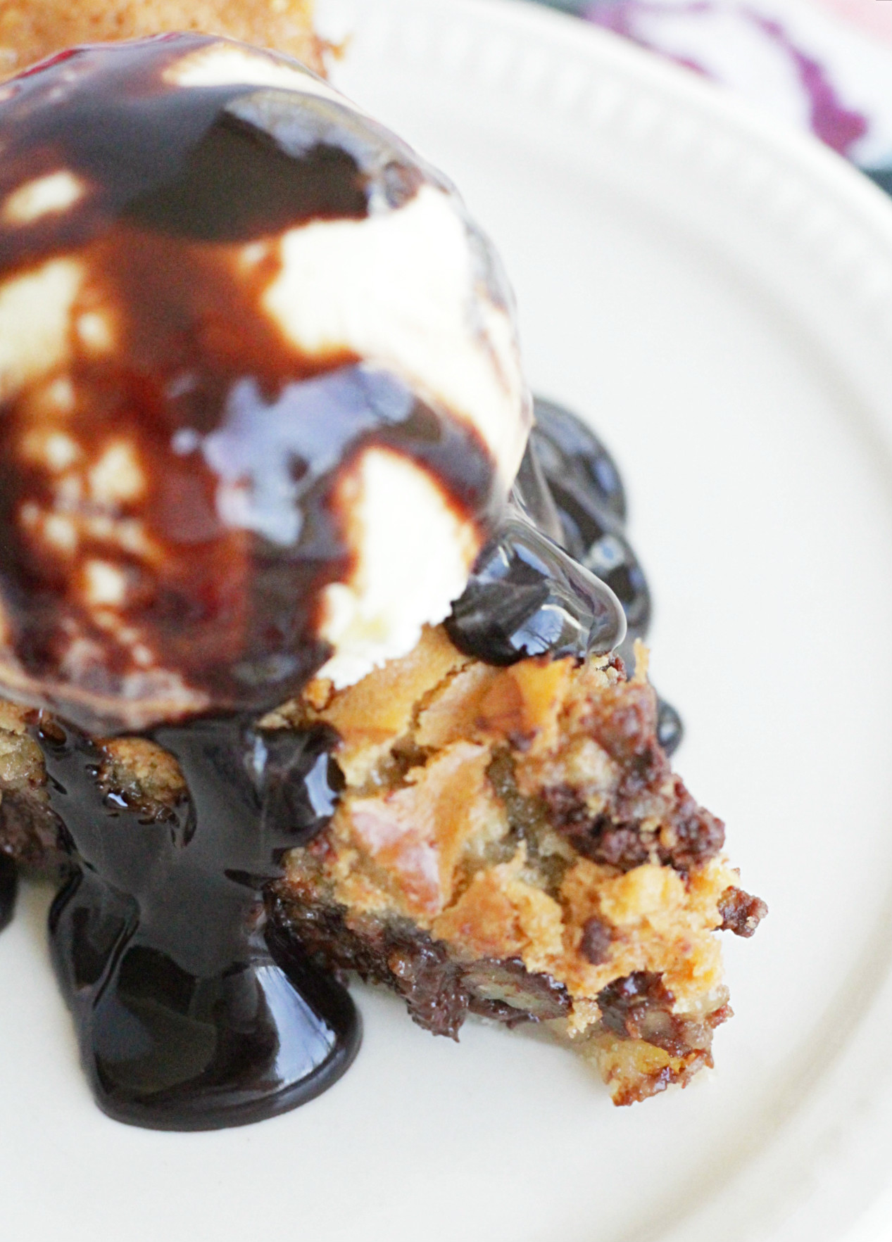 close up of chocolate chip cookie pie with ice cream and hot fudge