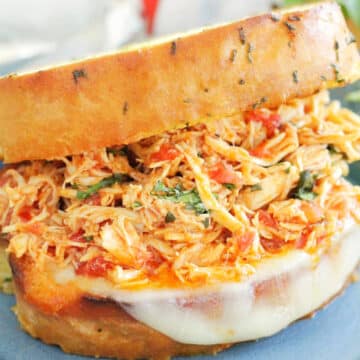 plated italian chicken sandwich on garlic bread with provolone cheese