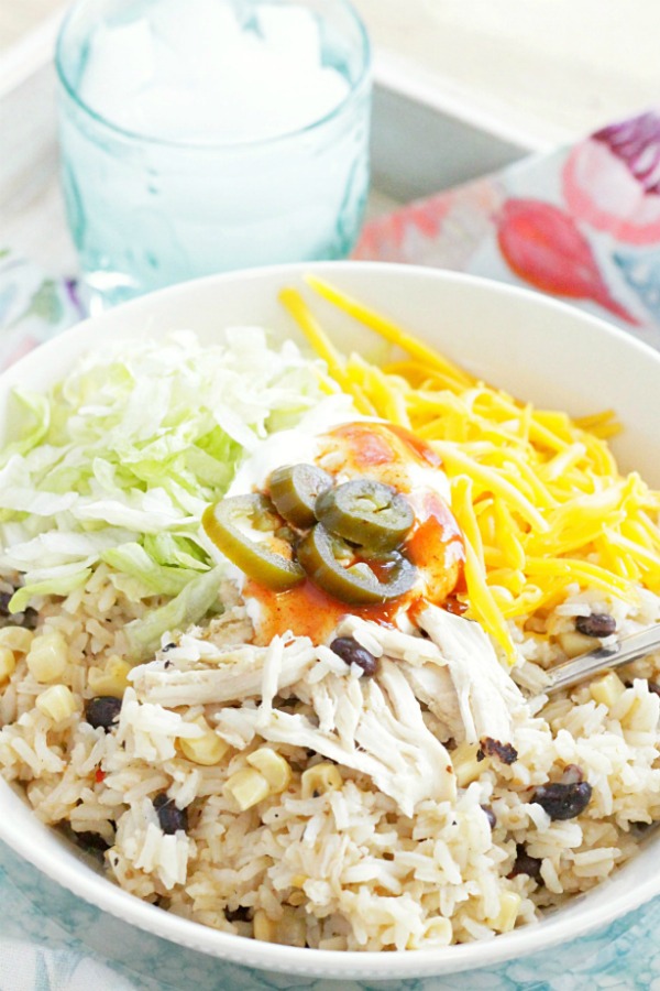 loaded chicken burrito bowl with glass of water