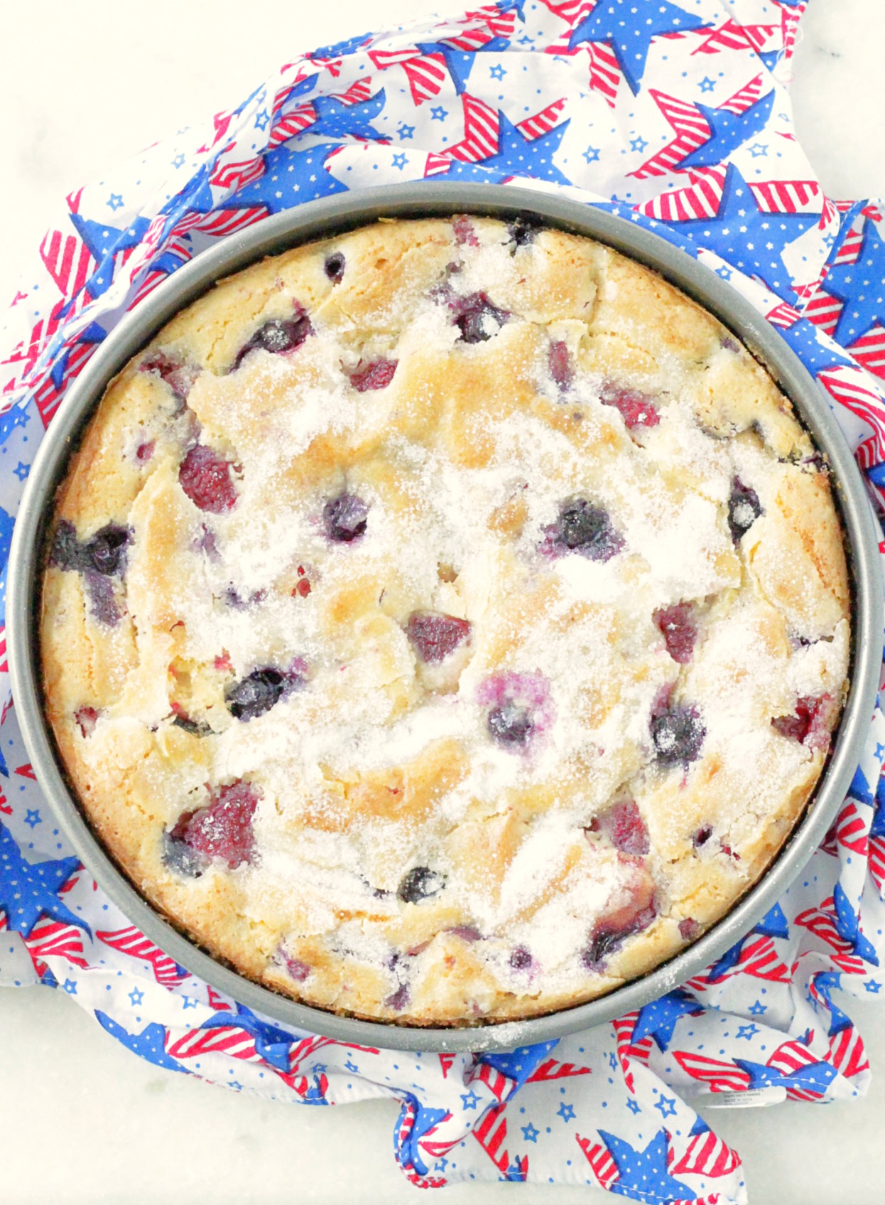 top view of whole red white and blue berry cake in the pan