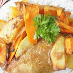 applesauce baked pork chop on a plate with roasted potatoes