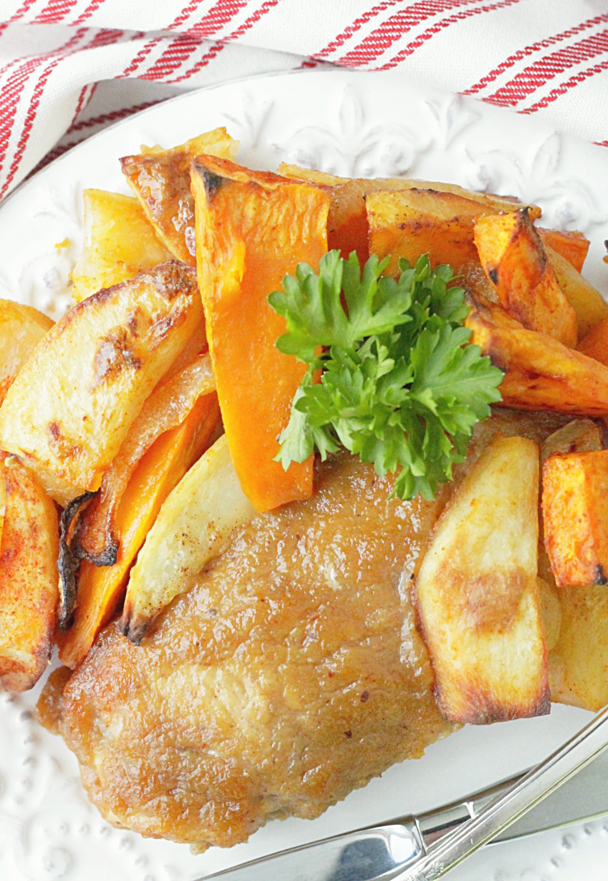 applesauce baked pork chop on a plate with roasted potatoes