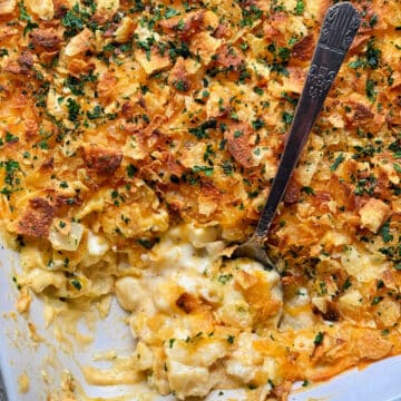 cheesy potatoes with a serving missing from the corner of the baking dish