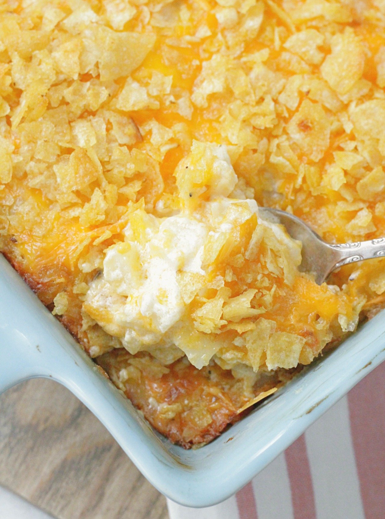 cheesy potatoes being spooned out of dish