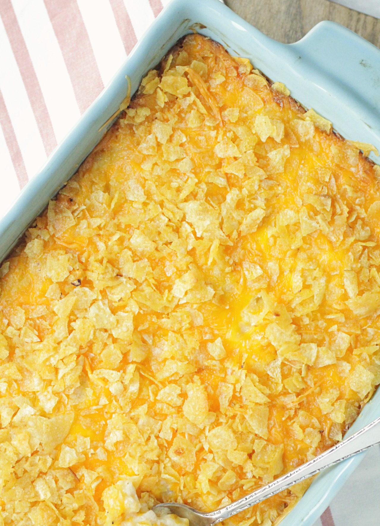 overhead of cheesy potatoes in aqua casserole dish